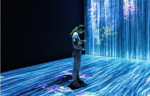 A woman standing in a projected light show.