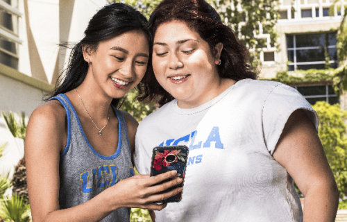 UCLA students using a mobile phone at the Athletics Corridor.