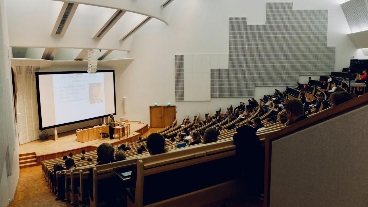A person speaking to a crowd in a UCLA lecture hall.