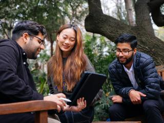 Three people collaborating outside.